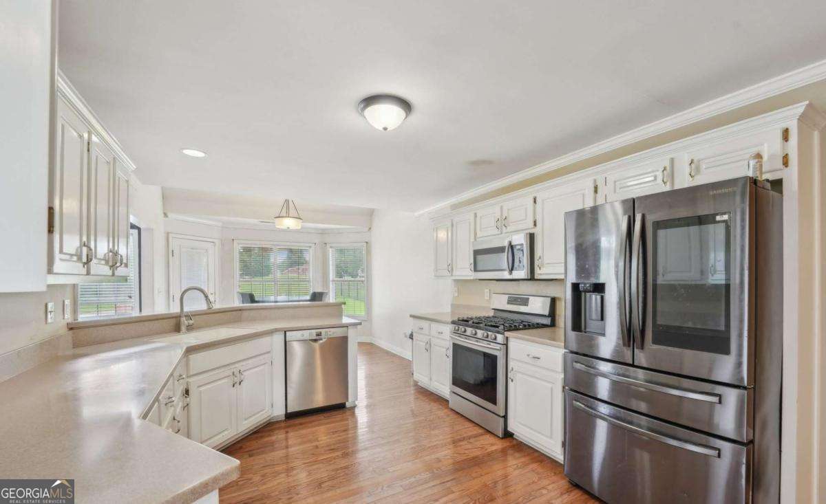1535 Lake Dow Road McDonough, GA 30252 - Photo 5 of 9 a large kitchen with stainless steel appliances granite countertop a stove and a sink