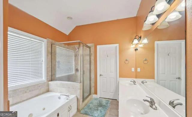 a bathroom with a tub sink and mirror