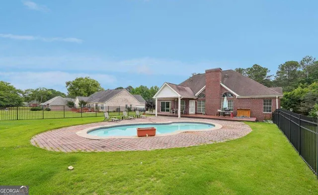 a front view of a house with garden and trees