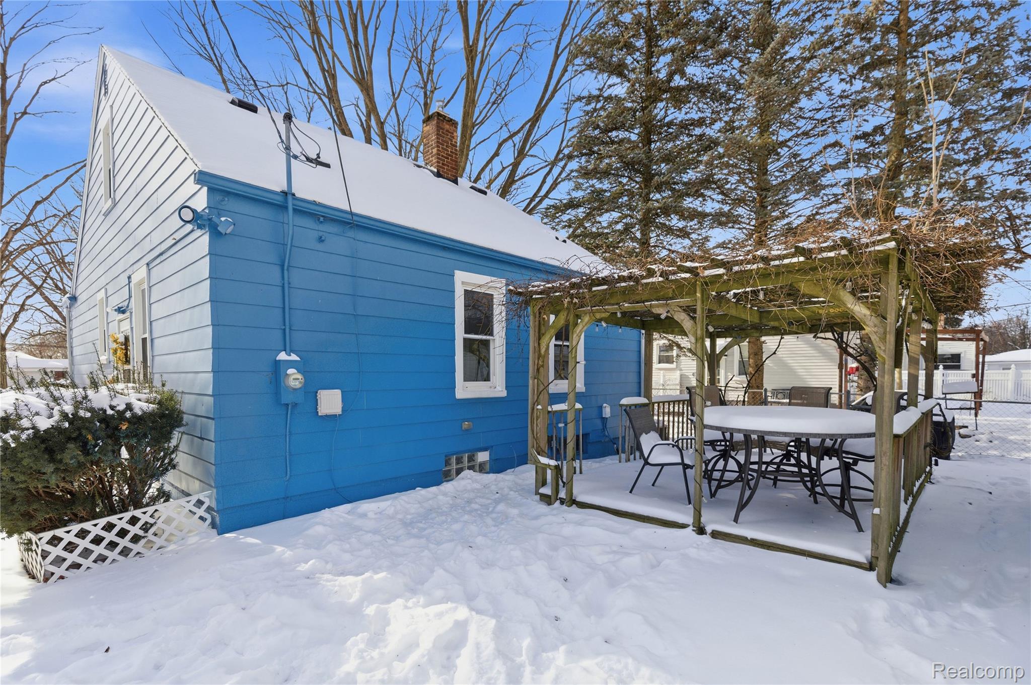26104 Student Street Redford, MI 48239 - Photo 25 of 30 Snow covered property featuring a chimney, outdoor dining space, a pergola, and a deck