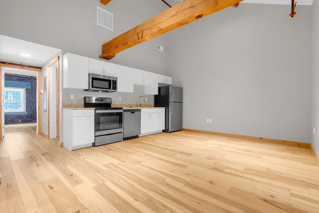 a view of kitchen with microwave oven stove and refrigerator