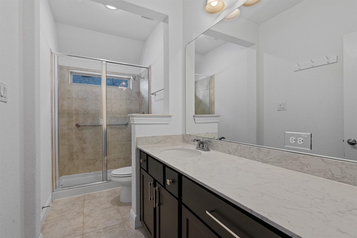 2328 Lucky Lane Leander, TX 78641 - Photo 29 of 40 a bathroom with a granite countertop sink a toilet and shower