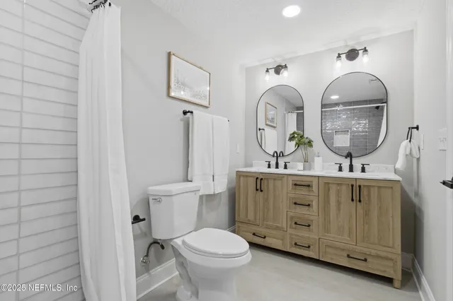 a bathroom with a granite countertop toilet a sink and a mirror
