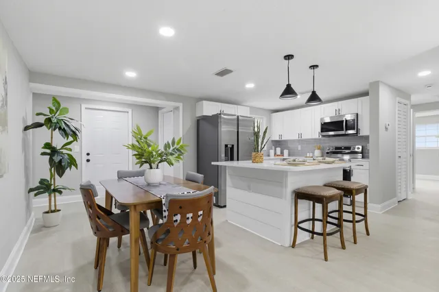 a kitchen with kitchen island a table and chairs in it