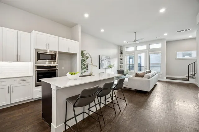 a kitchen with kitchen island a wooden floor and white appliances