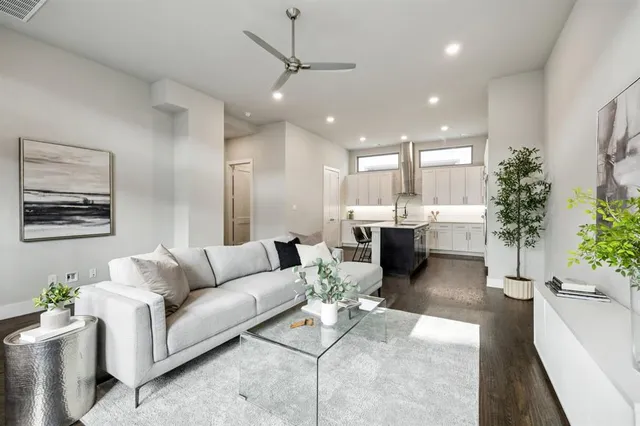a living room with furniture kitchen view and a potted plant