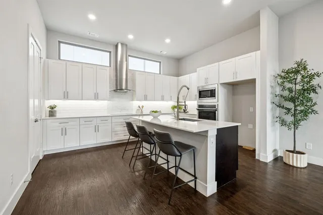 a kitchen with a sink a microwave a refrigerator and wooden floor