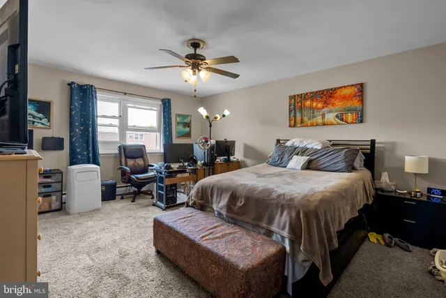 a spacious bedroom with a bed a couch and a chandelier