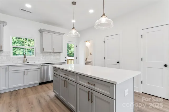 a kitchen with white cabinets and window