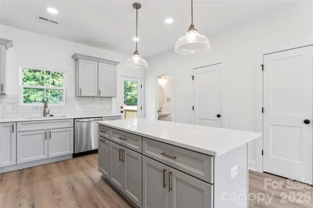 a kitchen with white cabinets and window