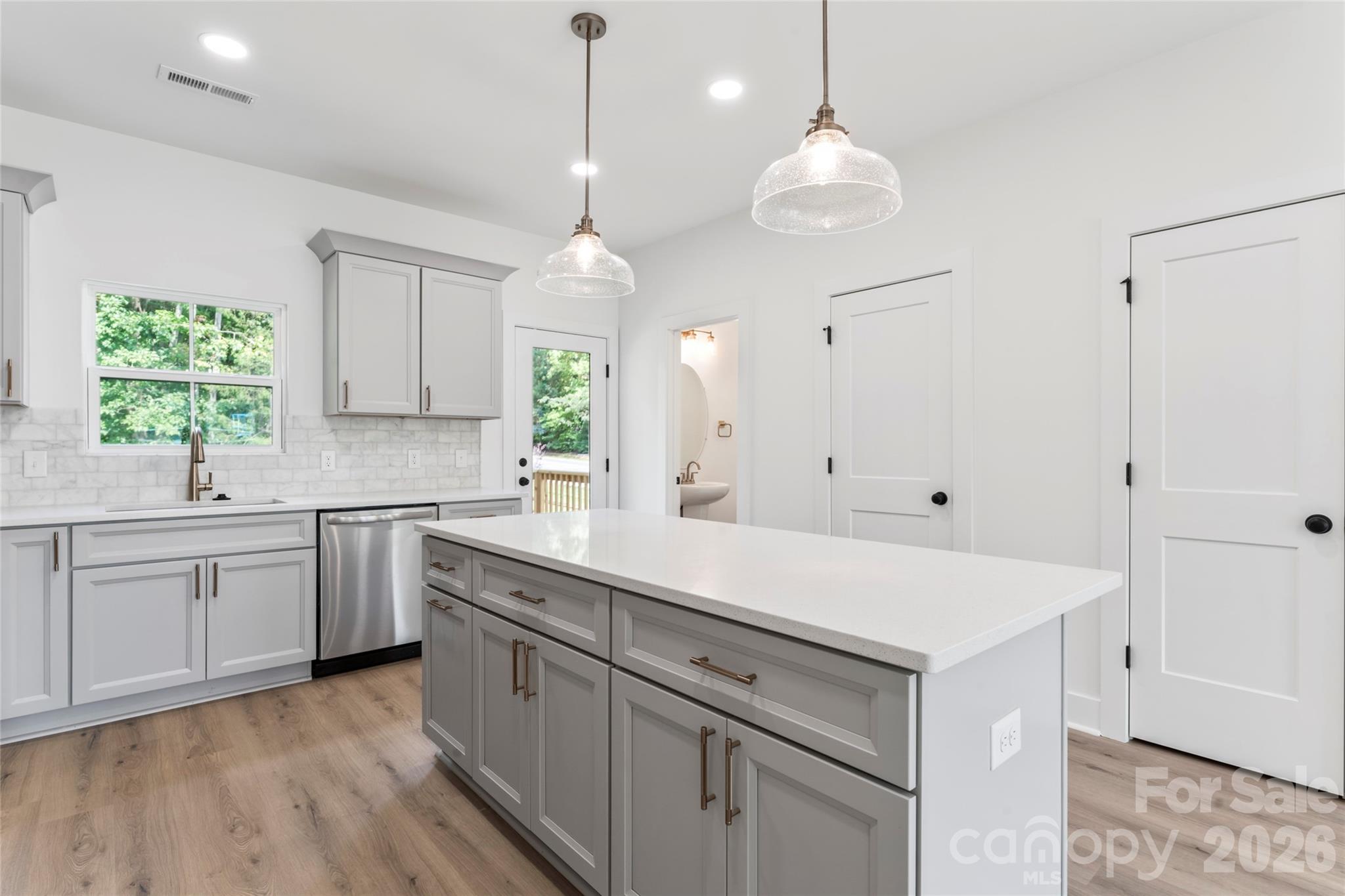 a kitchen with white cabinets and window