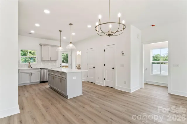 a large kitchen with a lot of cabinets and wooden floor