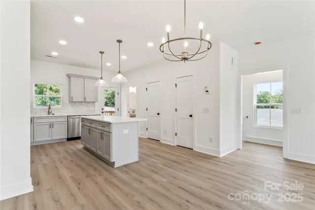 a large kitchen with a lot of cabinets and wooden floor