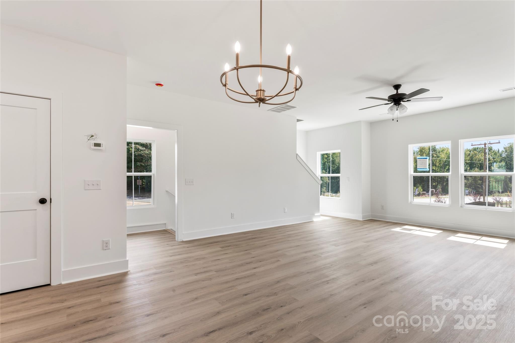 410 Bogue Drive, Unit 19 Fort Mill, SC 29708 - Photo 2 of 48 an empty room with wooden floor chandelier fan and windows