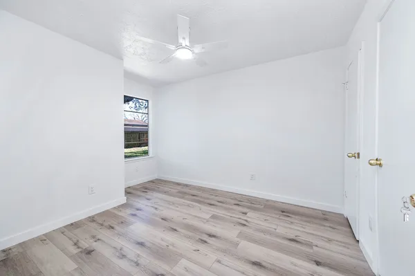 a view of an empty room with wooden floor
