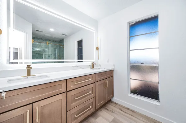 a bathroom with a double vanity sink and mirror