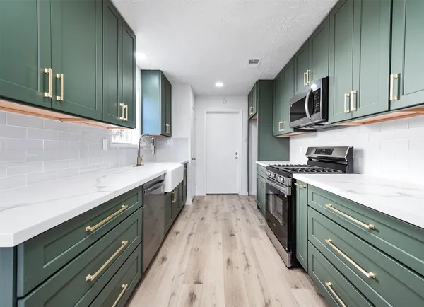a kitchen with stainless steel appliances granite countertop a sink and cabinets