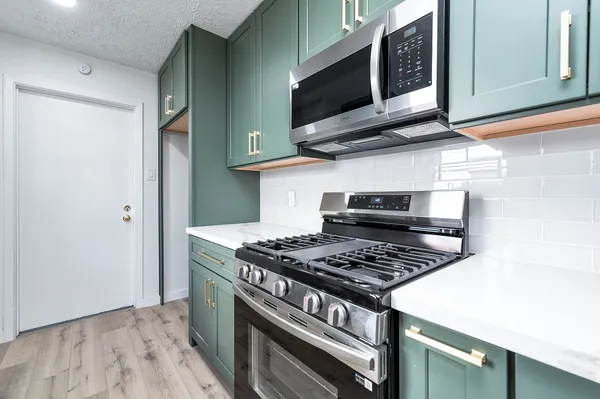 a kitchen with stainless steel appliances granite countertop a stove and a microwave
