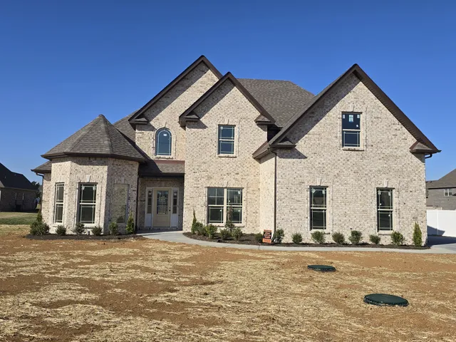 a view of a white house with a yard next to a road