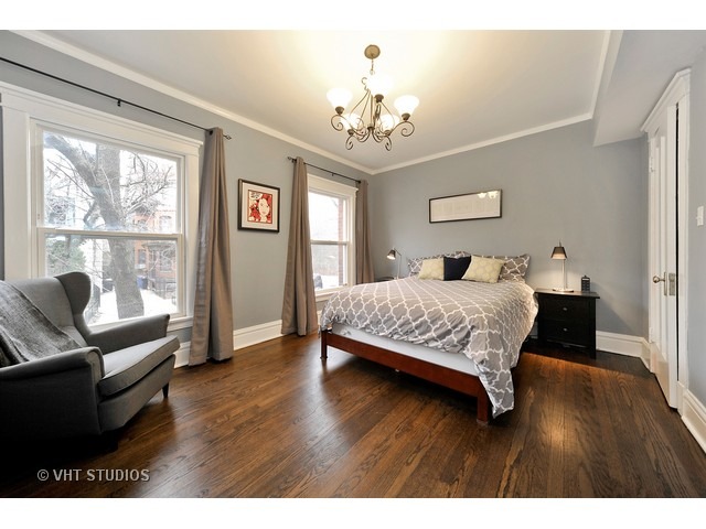 725 West Buckingham Place, Unit 1 Chicago, IL 60657 - Photo 7 of 12 a bedroom with a bed wooden floor and a large window