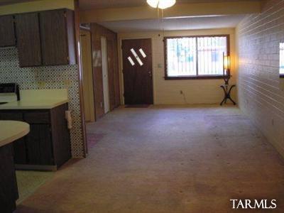 3986 North Pomona Road Tucson, AZ 85705 - Photo 3 of 13 an empty room with a fireplace and windows