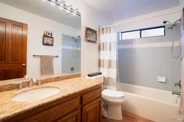 a bathroom with a granite countertop sink toilet and shower