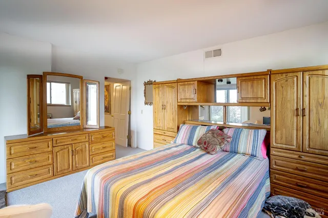 a bedroom with a large bed and a dresser