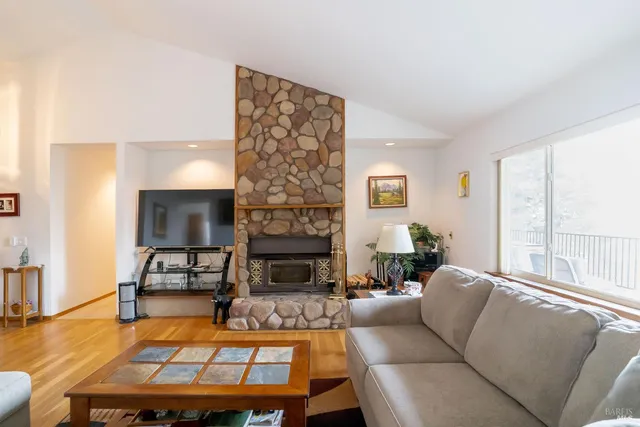 a living room with furniture a large window and a fireplace