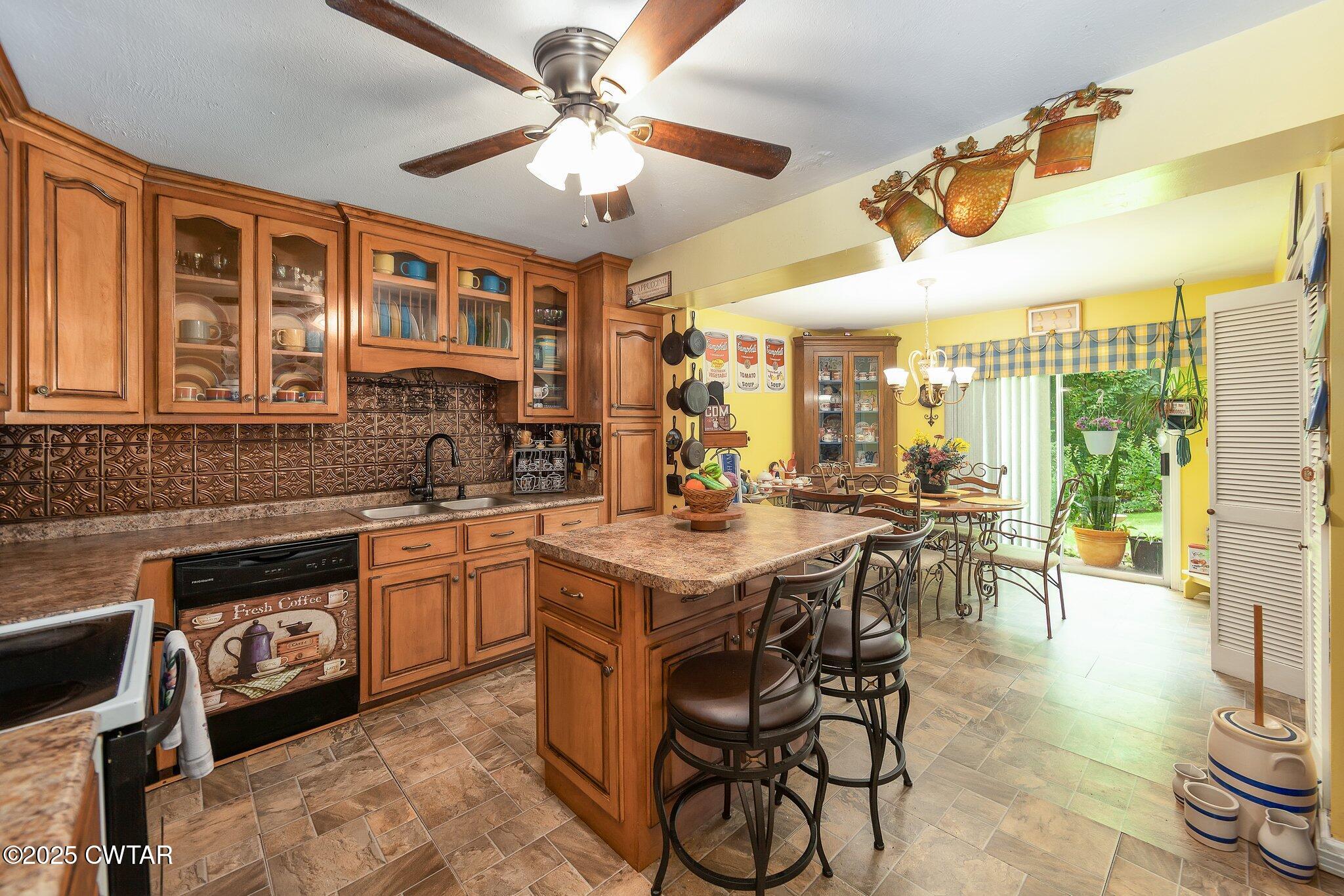 3600 Pine Top Road Toone, TN 38381 - Photo 10 of 39 a kitchen with stainless steel appliances granite countertop a stove top oven a sink a dining table and chairs with wooden floor