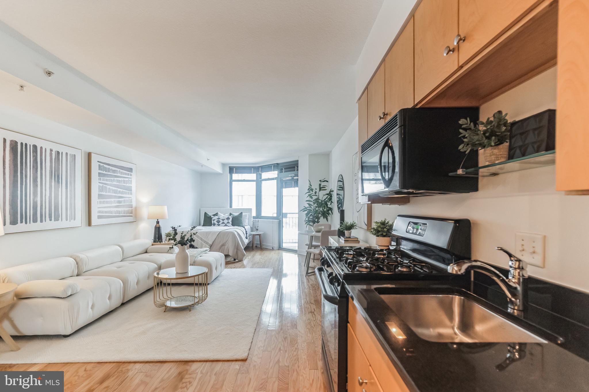 1117 10th Street Northwest, Unit 607 Washington, DC 20001 - Photo 6 of 20 a kitchen with stainless steel appliances granite countertop a sink a stove top oven a dining table and chairs