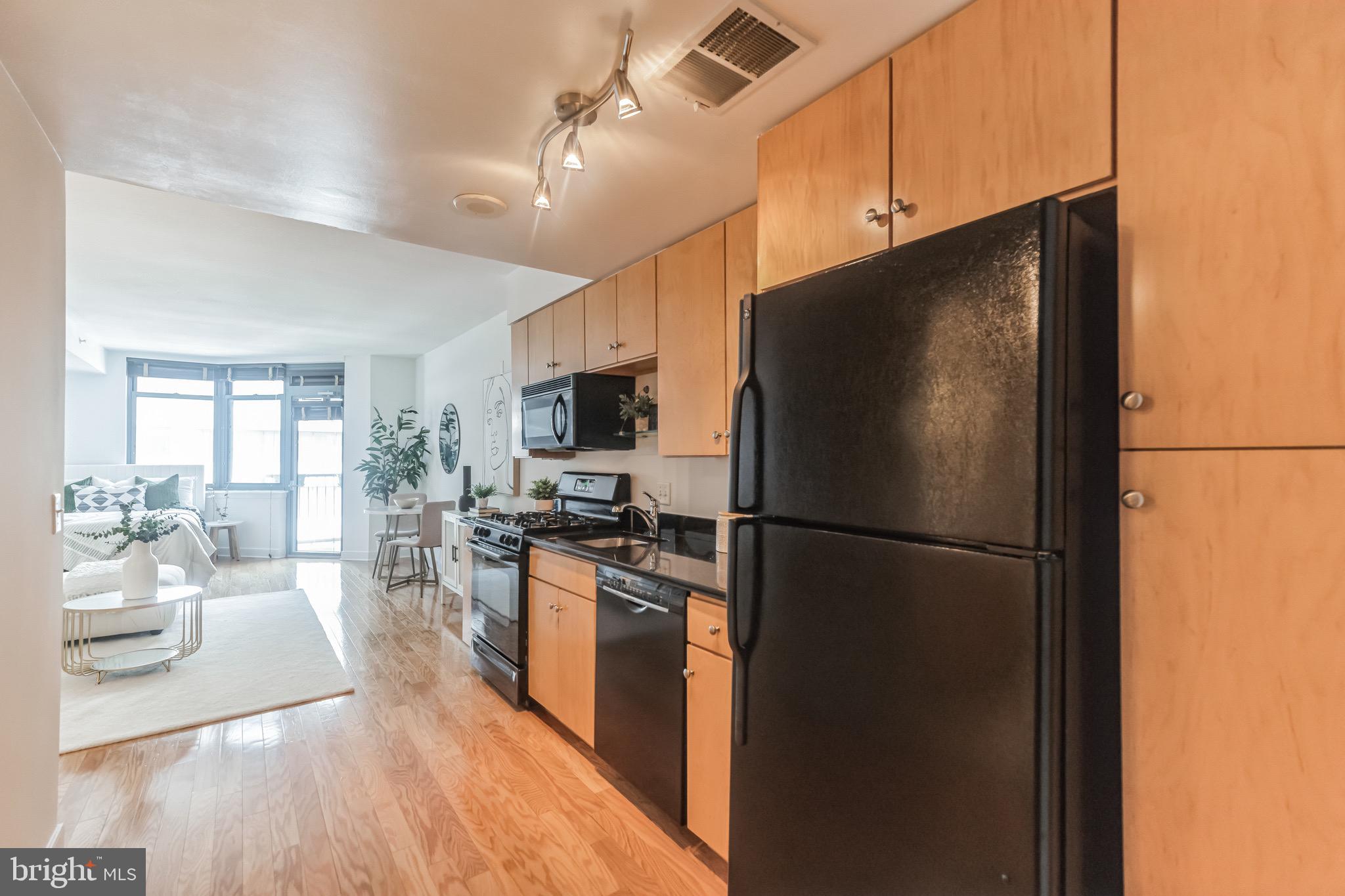 1117 10th Street Northwest, Unit 607 Washington, DC 20001 - Photo 8 of 20 a kitchen with stainless steel appliances a refrigerator a stove a sink dishwasher a oven with white cabinets and wooden floor