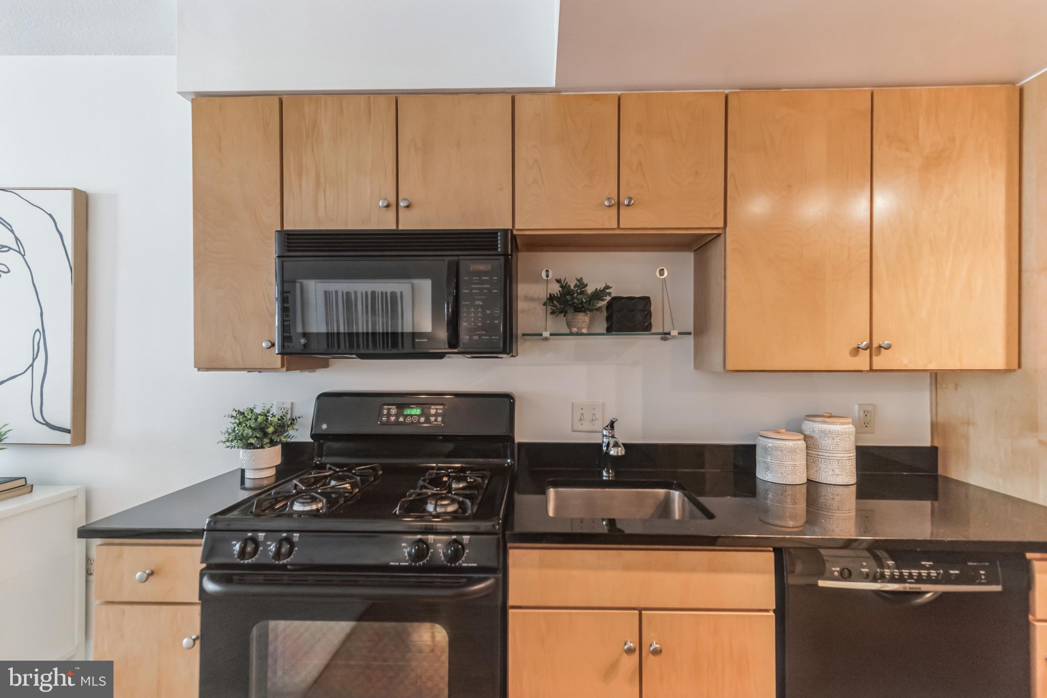 1117 10th Street Northwest, Unit 607 Washington, DC 20001 - Photo 9 of 20 a kitchen with stainless steel appliances granite countertop a stove a sink and a microwave