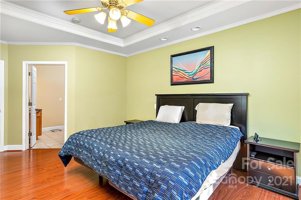 5628 Plantation Ridge Road Charlotte, NC 28214 - Photo 17 of 43 a bedroom with a bed and a chandelier