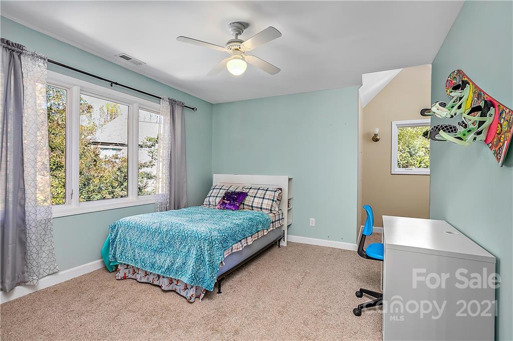 5628 Plantation Ridge Road Charlotte, NC 28214 - Photo 26 of 43 a bedroom with a bed and a chandelier