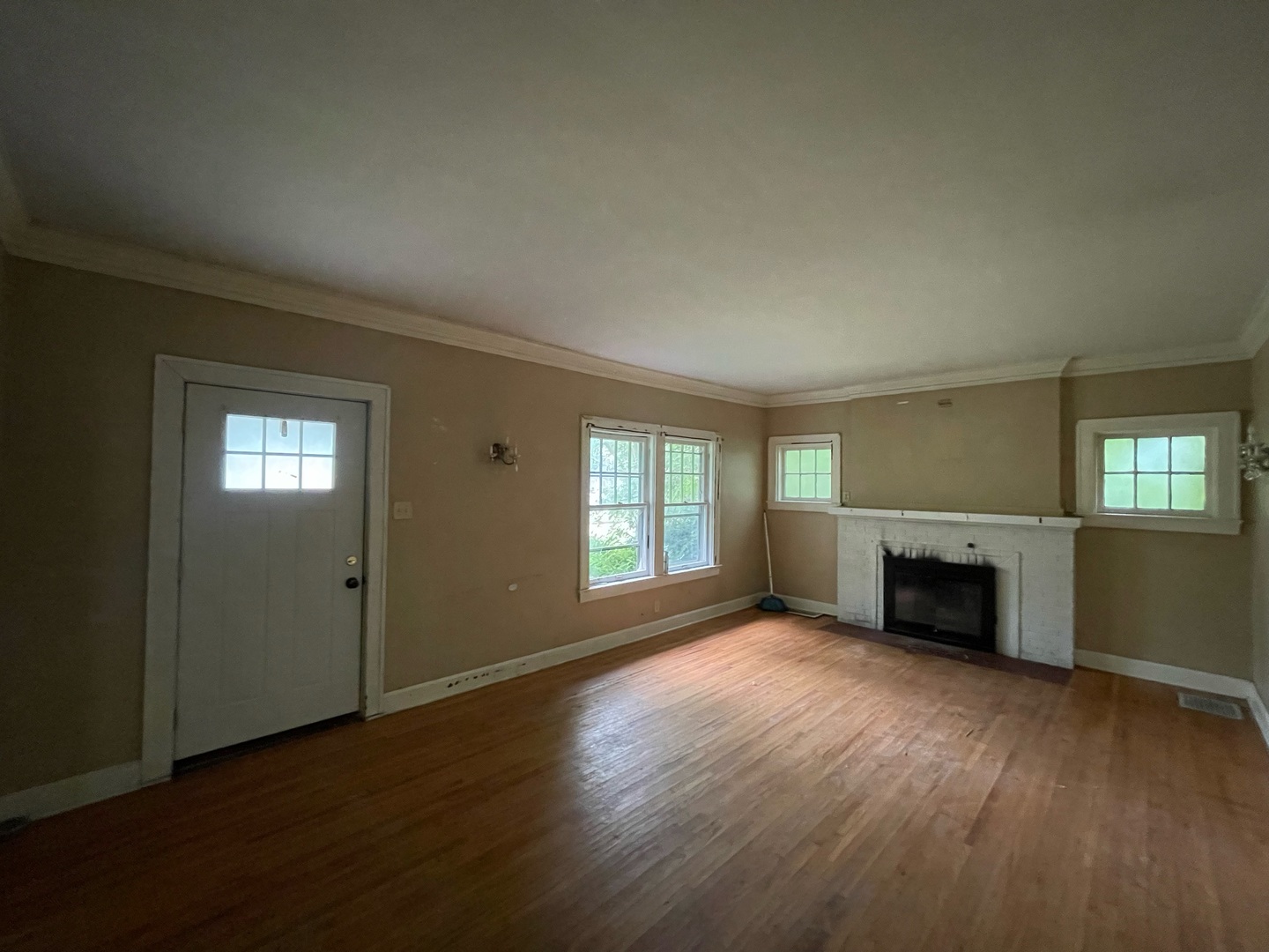 840 East Lincoln Street Hoopeston, IL 60942 - Photo 6 of 33 an empty room with windows a fireplace and wooden floor