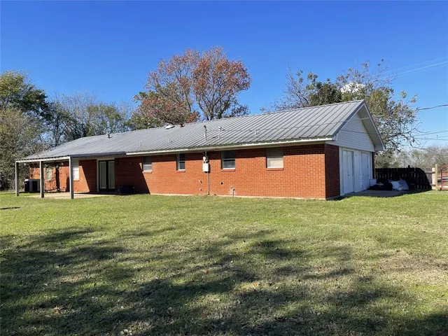 a front view of house with outdoor space and trees all around