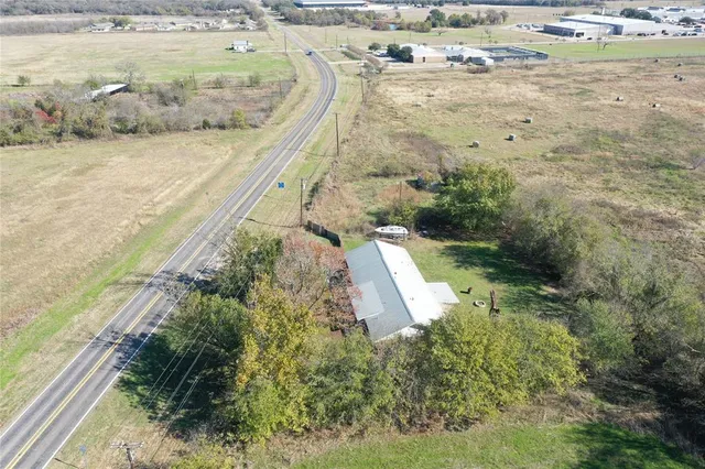 a view of house with yard and tree in front of it
