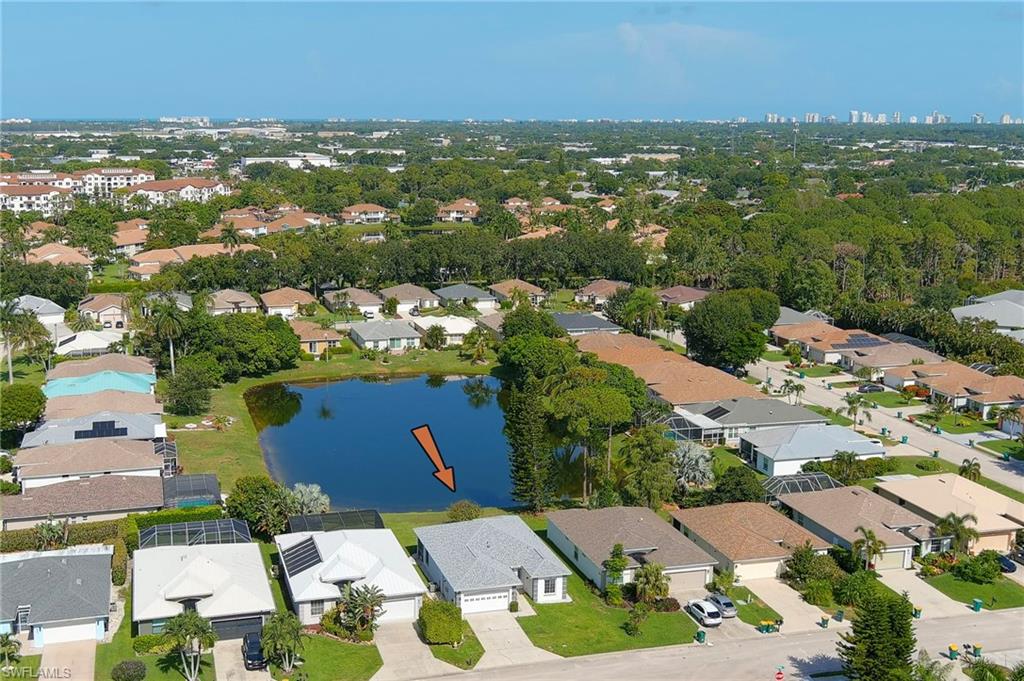 223 Stanhope Circle Naples, FL 34104 - Photo 31 of 41 Lakeside property featuring mature landscaping and a well-maintained lawn