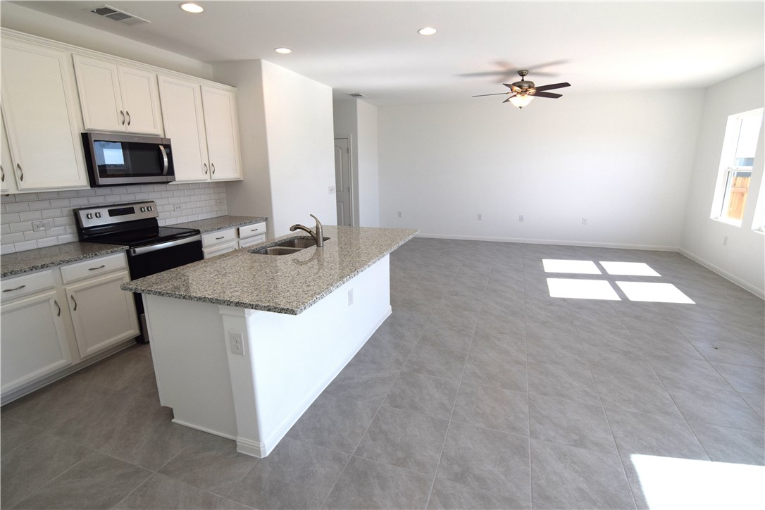 6705 Routenburn Street Austin, TX 78754 - Photo 2 of 18 a kitchen with kitchen island granite countertop a sink a counter top space appliances and cabinets