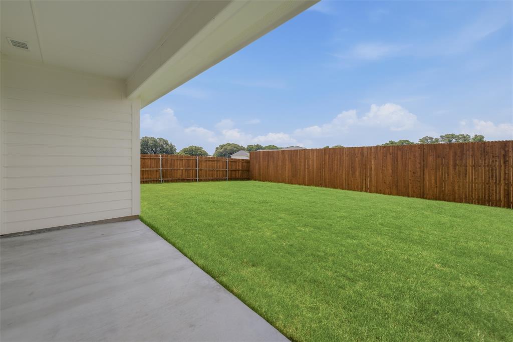 1232 Colca Drive Springtown, TX 76082 - Photo 19 of 23 Covered patio with a concrete slab, expansive green lawn, and wood privacy fencing