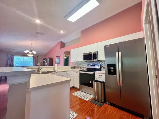 a kitchen with stainless steel appliances kitchen island granite countertop a refrigerator stove microwave and sink