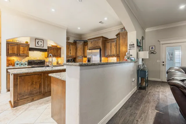 a kitchen with stainless steel appliances granite countertop a stove a sink and a refrigerator