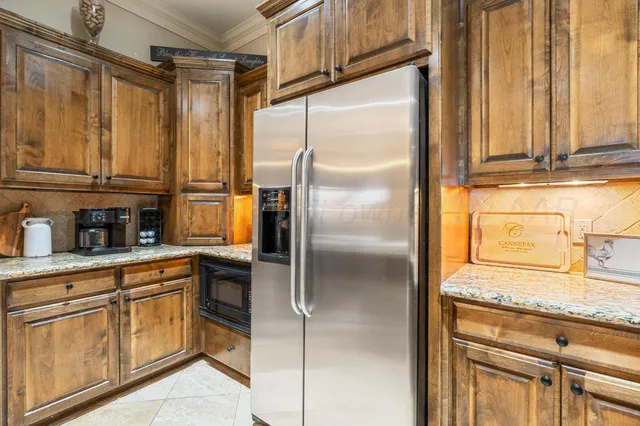 a kitchen with stainless steel appliances granite countertop a refrigerator and a sink