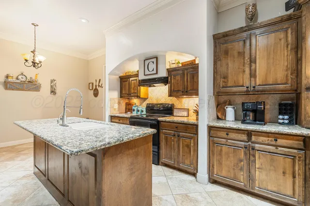 a kitchen with granite countertop cabinets a sink a stove and a wooden floors