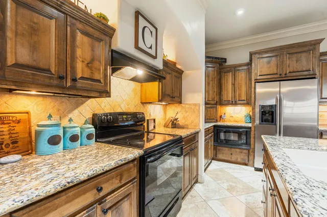 a kitchen with stainless steel appliances granite countertop a sink stove and refrigerator