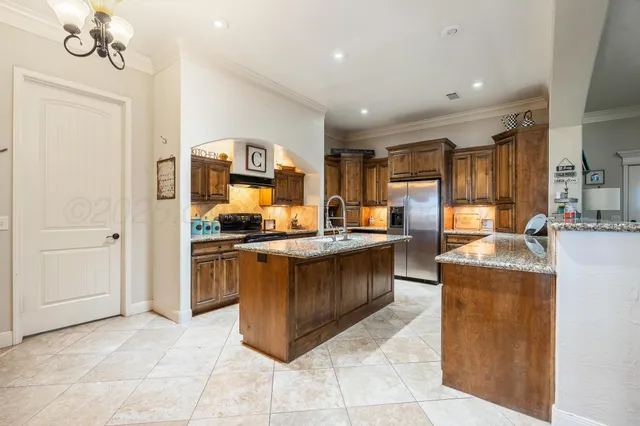 a kitchen with stainless steel appliances granite countertop a refrigerator and a stove top oven
