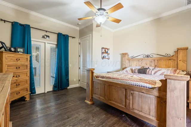 a bedroom with a bed a dresser and a chandelier