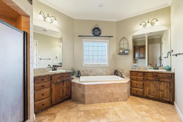 a spacious bathroom with a tub sink and mirror