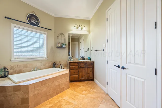 a spacious bathroom with a tub sink and mirror