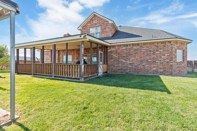 a view of a house with a yard and deck